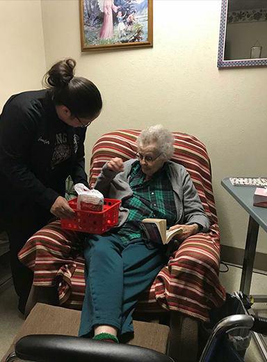 Team member giving older patient a gift