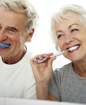 senior couple brushing their teeth