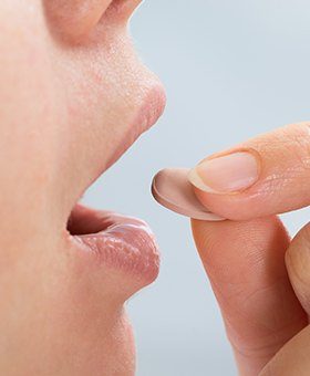 Closeup of person taking oral conscious sedative pill