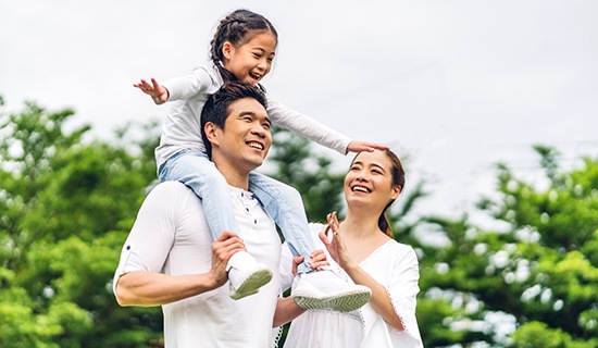 Parents and their child smiling after visiting their Assurant dentist in Mangum