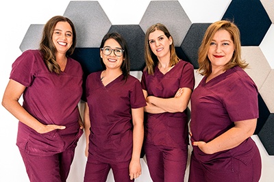 Dental team in scrubs and smiling