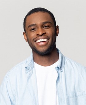 Man in light blue button up shirt smiling