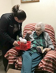 Team member giving gift to senior citizen at community event