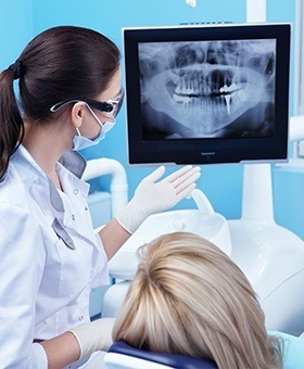 Patient and team member looking at digital dental x-rays