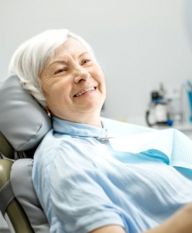 woman admiring her smile after getting dentures