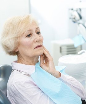 senior woman with tooth pain talking to dentist 