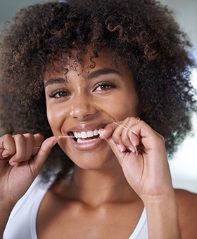 woman smiling while flossing 