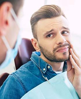 Pained man visiting his Mangum emergency dentist