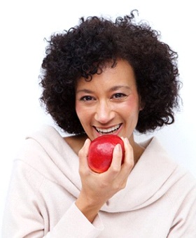 woman biting into red apple