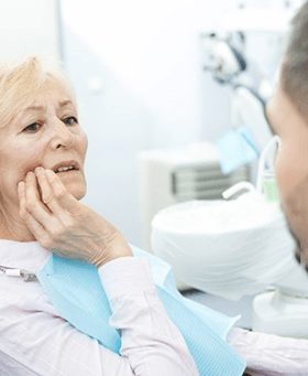 a patient discussing dental implant salvage with her dentist
