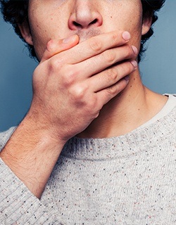 Closeup of a hand over the mouth