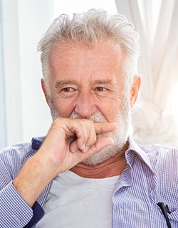 Older man covering his mouth