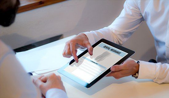 Team members and patient looking and insurance forms