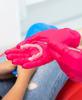 Dentist showing patient Invisalign trays