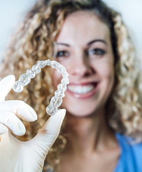 Dentist holding up Invisalign tray