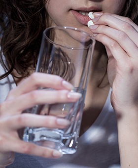 Woman preparing to swallow sedative medication