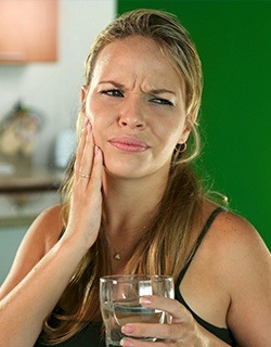Grimacing woman holding jaw