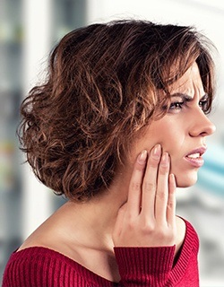 Woman in pain holding cheek