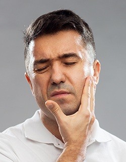 Man holding cheek