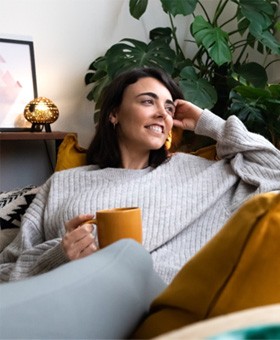 Woman in grey sweater relaxing at home