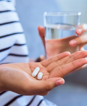 Close-up of hand holding a couple of painkiller pills
