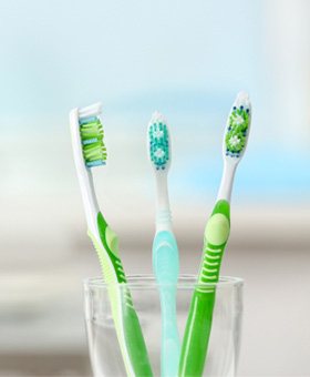 Close-up of a cup with three toothbrushes