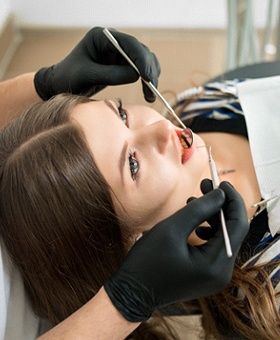 A young female having her dentist check her oral cavity after suffering from a dental emergency