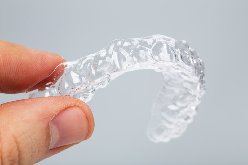 Person holding an Invisalign aligner